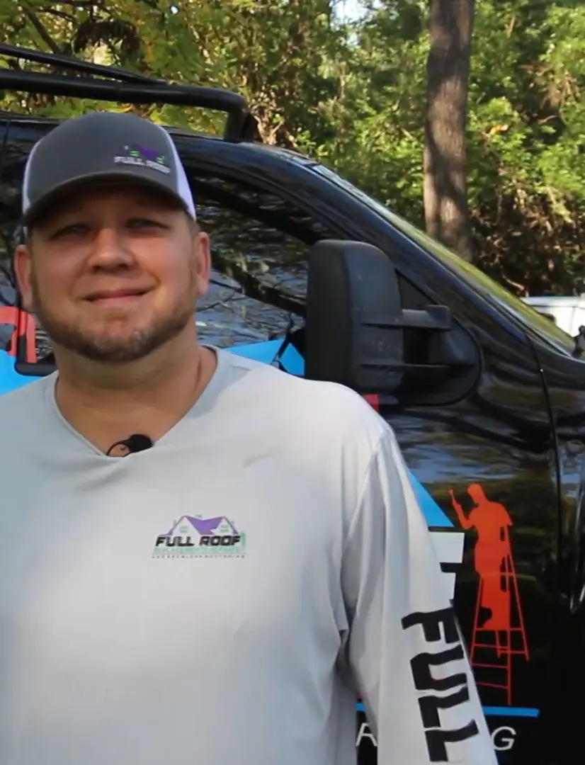 Bo, owner of Full Roof, standing in front of the company truck