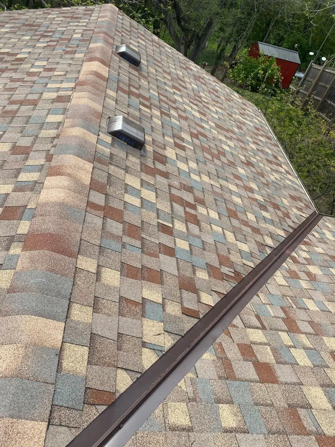 Multi-color blend shingles finished with ridge cap and box vents