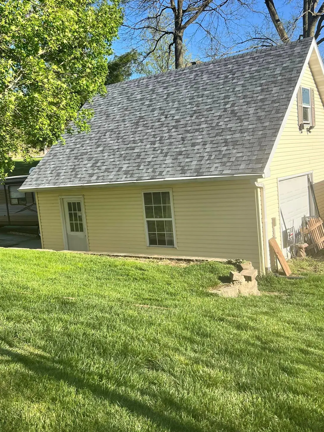 The same detached garage with a new gray architectural shingle roof