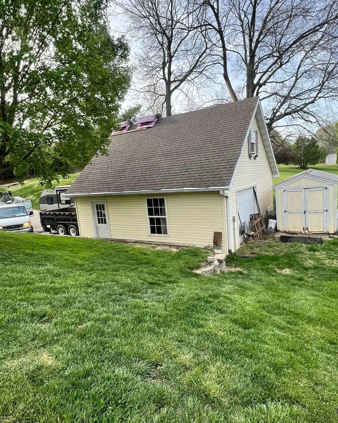 Detached garage with its old worn shingle roof before the replacement
