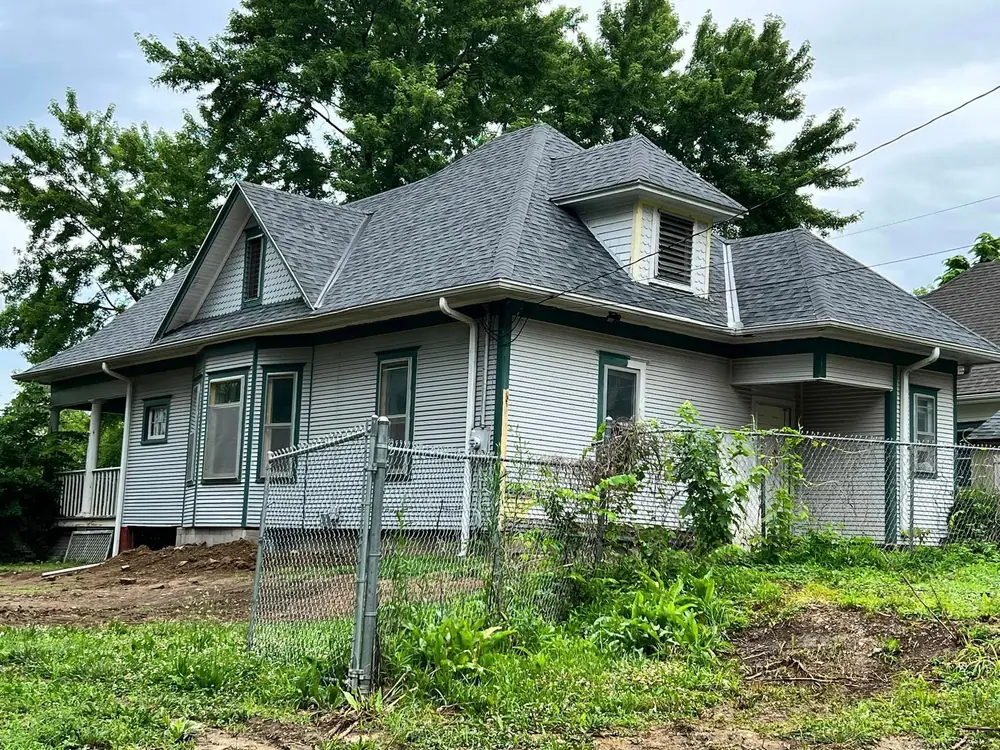 Two-story house with green trim and a new shingle roof