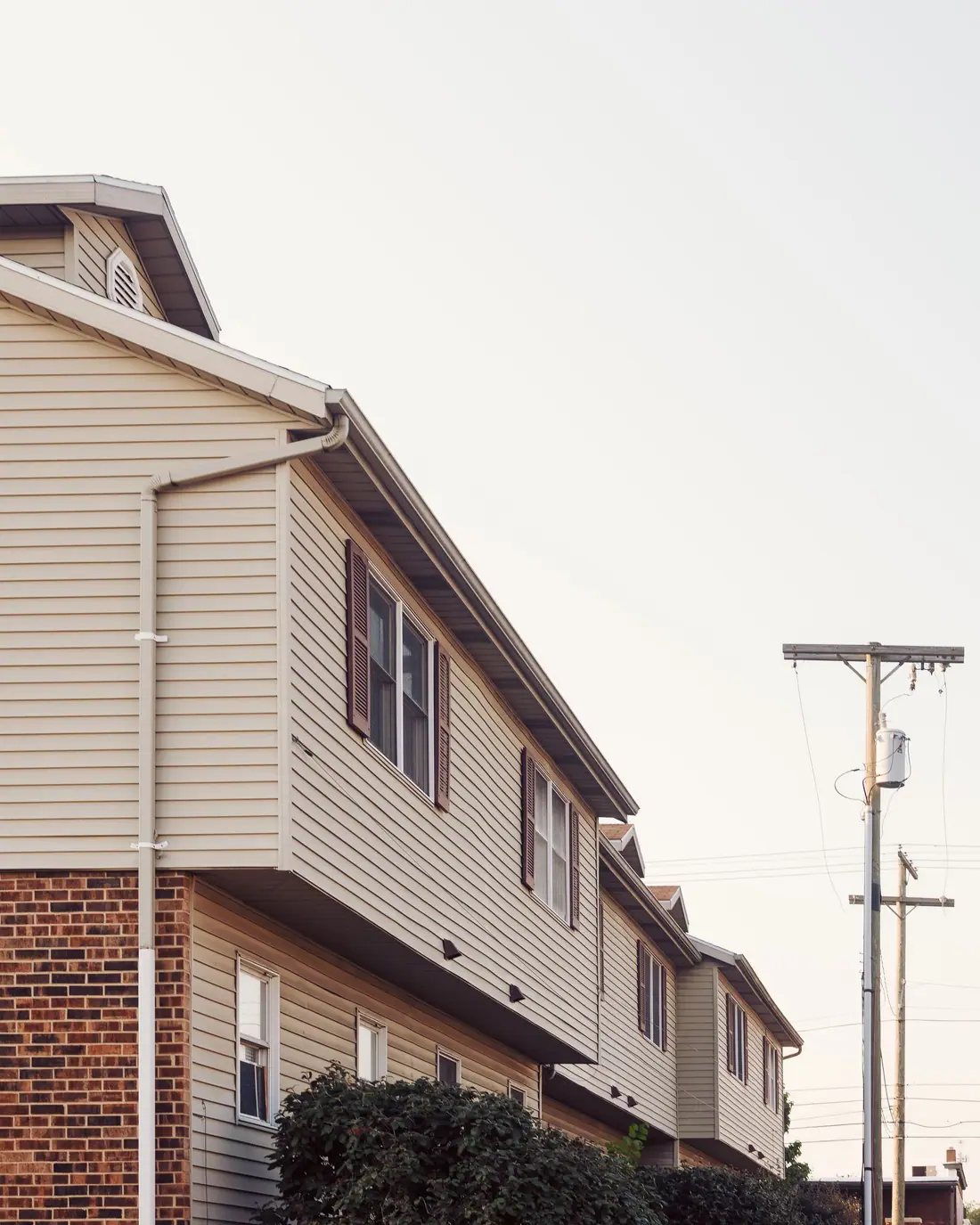 Seamless gutter and downspout running along the eave of a two-story house