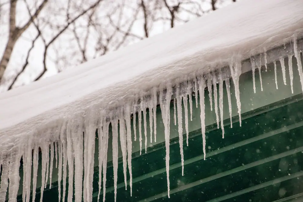 Long icicles hanging from a snow-loaded roof edge