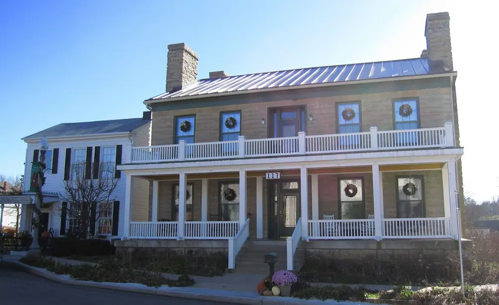Historic two-story building with a metal roof and porches in Platte City, Missouri
